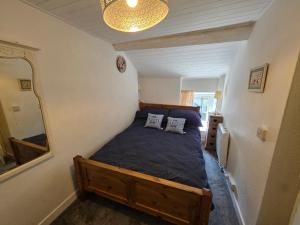 ein Schlafzimmer mit einem Bett mit zwei Kissen darauf in der Unterkunft Pet friendly two bedroom cosy cottage in Tanygrisiau