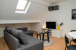 a living room with a couch and a tv at Chic & Modern 1BR & 1LR Apt, 12 Min Walk to Rabot in Ghent