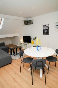 a living room with a white table and chairs at Chic & Modern 1BR & 1LR Apt, 12 Min Walk to Rabot in Ghent +20 photos