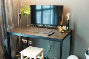 a television sitting on a desk with a keyboard at Zimmer in Atelierwohnung in Cologne