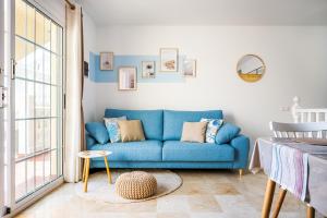 a blue couch in a living room with a window at Casita Azul Las Arenas in Caleta De Fuste