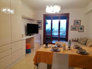 a kitchen and living room with a table and a television at Sulla spiaggia di Letojanni in Letojanni