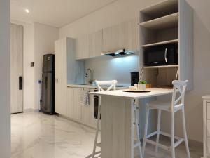 a kitchen with a white island with two stools at Patty del Mar Suites in Santa Marta