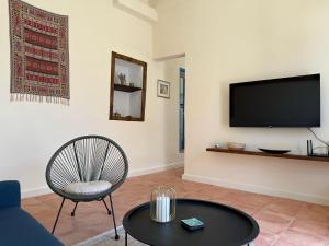a living room with a tv and a chair and a table at iris house in Kalo Chorio