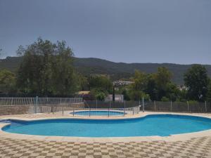a large blue pool with a fence and trees at El mirador de El Bosque in El Bosque