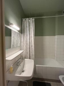 a bathroom with a sink and a bath tub at Appartement centre ville de Bourg d'Oisans in Le Bourg-dʼOisans +6 photos