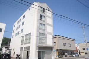 a white building on the corner of a street at Hotel Miyuki in Wakkanai