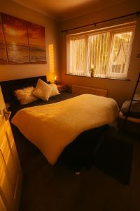 a bedroom with a large bed with a window at Lister Park Bradford 2bed Detached Cottage House Parking Cinema Screen Games Room in Bradford