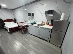 a kitchen with a sink and a refrigerator and a bed at Apartamento doña Lety in Fortuna