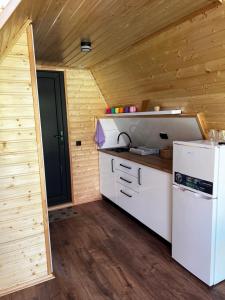 une cuisine avec un réfrigérateur blanc et un mur en bois dans l'établissement Sweet Cottage, à Kobuleti