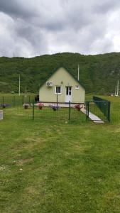 a small house in a field with a fence at Home Delic Komarnica in Šavnik