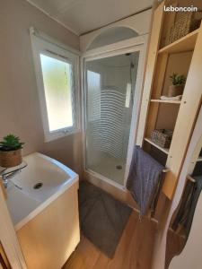 a small bathroom with a shower and a sink at Mobil home, camping les pins maritimes in Hyères