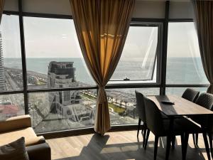a room with a table and chairs and a large window at venus apart hotel in Batumi