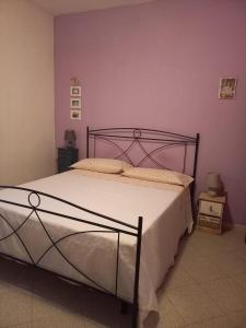 a bed in a bedroom with a purple wall at Vacanze da Susy Casa Silvana in Passignano sul Trasimeno