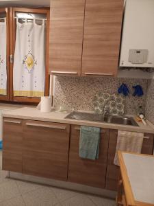 a kitchen with wooden cabinets and a sink and a window at Vacanze da Susy Casa Silvana in Passignano sul Trasimeno