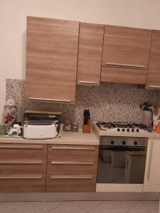 a kitchen with wooden cabinets and a stove top oven at Vacanze da Susy Casa Silvana in Passignano sul Trasimeno
