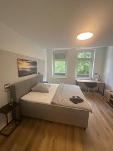 a bedroom with a bed and a desk and two windows at Wohlfühl-Oase in Herne