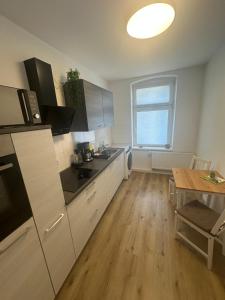 a kitchen with white cabinets and a table and a window at Wohlfühl-Oase in Herne +21 photos