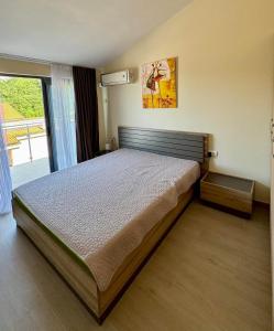 a bedroom with a large bed in front of a window at Charming apartment near beach in Sveti Stefan
