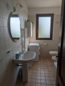 a bathroom with a sink and a toilet and a mirror at Appartamento piano terra Montone in Montone