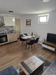 a living room with a table and a kitchen at Holiday House Slavonska oaza in Sikirevci +14 photos