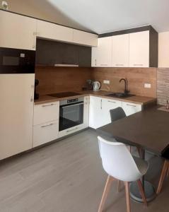 a kitchen with white appliances and a table and chairs at Charming apartment near beach in Sveti Stefan +42 photos