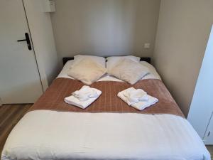 Una cama con dos toallas encima. en Studio lumineux 2 pers Olivet Avenue Loiret, en Olivet