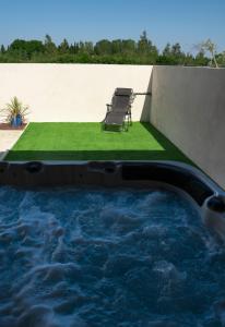 Una piscina de inmersión con una silla en un patio trasero. en LES JARDINS D'ORANGE, en Orange
