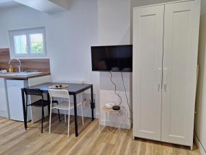 una cocina con una mesa pequeña y una cocina con barra en Studio lumineux 2 pers Olivet Avenue Loiret, en Olivet