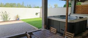Un jacuzzi en un patio con dos sillas. en LES JARDINS D'ORANGE, en Orange