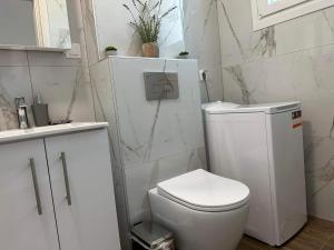 スカラ・ラクニオウにあるOlive Luxury Apartmentのトイレと洗面台を備えた白いバスルーム +6枚の写真