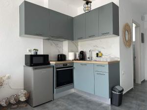 スカラ・ラクニオウにあるOlive Luxury Apartmentの青いキャビネットとカウンタートップを備えたキッチン
