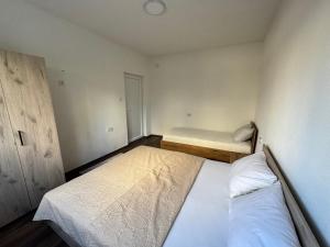 a small bedroom with two beds and a bench at Teona Apartment in Ohrid