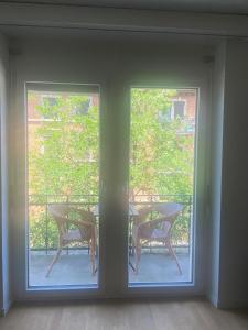 Habitación con 2 ventanas, mesa y sillas en KAYA Zurich Apartment PARAIBA- Downtown Deluxe 2BR Apt, en Zúrich