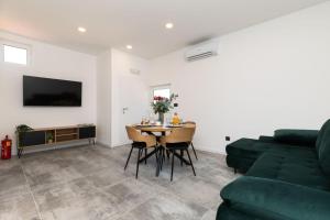a living room with a green couch and a table at Alexis Residence in Mali Lošinj +85 photos