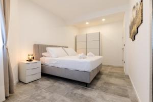 a bedroom with a white bed and a white cabinet at Alexis Residence in Mali Lošinj