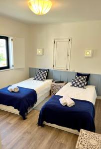 two beds in a room with blue and white at Delta Marina Vilamoura in Quarteira