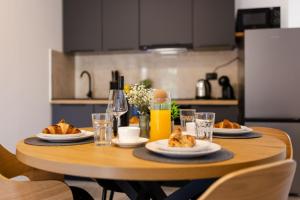 a wooden table with plates of food on it at Alexis Residence in Mali Lošinj