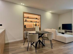 a living room with a table and chairs and a tv at Apartamento do Ferreiro in Ponte da Barca
