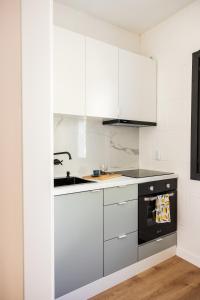 a kitchen with white cabinets and a sink and a stove at Céntrico y moderno apartamento en Cazorla in Cazorla