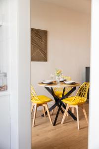 a dining room with a table and yellow chairs at Céntrico y moderno apartamento en Cazorla in Cazorla