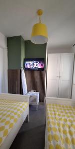 a bedroom with two beds and a tv in the wall at Domus Lapidea in Postira