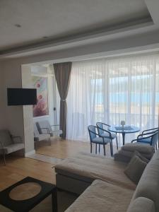 a living room with a couch and a table and chairs at Apartman Relax Čelebići in Konjic