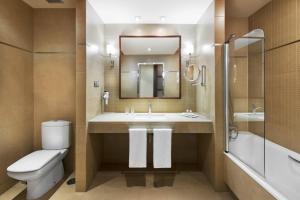 
a bathroom with a toilet a sink and a bathtub at Elba Almeria Business & Convention Hotel in Almería
