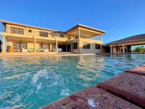 a swimming pool in front of a house at Ambience on N2 Boutique Hotel in Kokstad