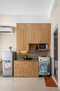 a kitchen with wooden cabinets and a refrigerator at Urban Stay Saigon Dictrict 4 in Ho Chi Minh City