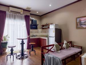 a living room with a table and a kitchen at Phonethip Residence, Khouvieng in Vientiane