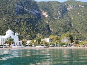 a white building on the shore of a body of water at Hotel Matina in Kamena Vourla