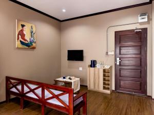 a room with a brown door and a table and a tv at Phonethip Residence, Khouvieng in Vientiane