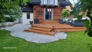 a backyard with a deck and a log cabin at Domek U Babci in Istebna